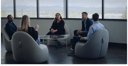 Group of employees sitting in low chairs having a discussion